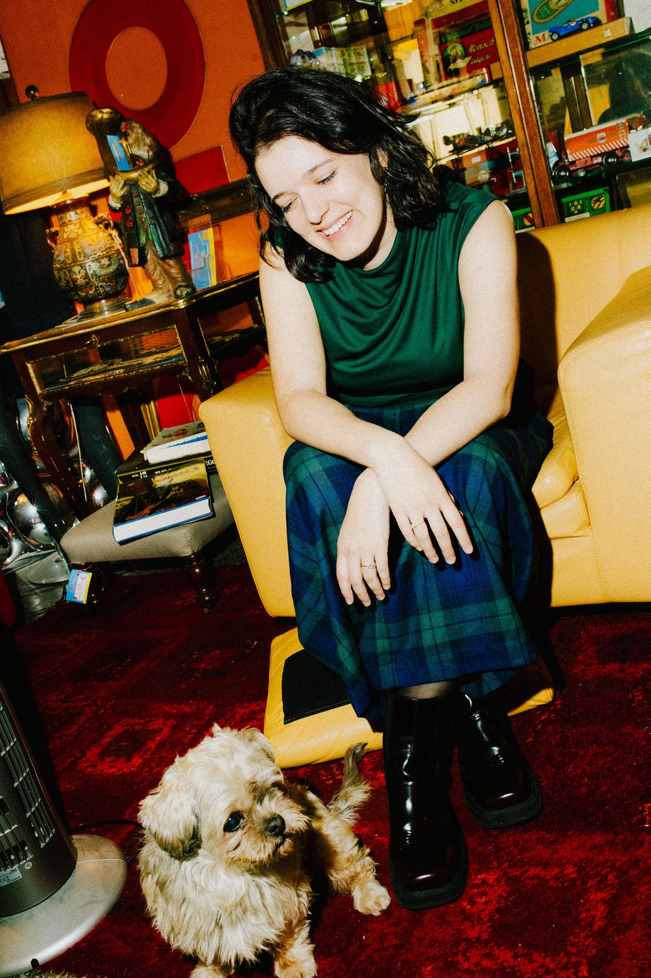 In an armchair with a small dog at her feet